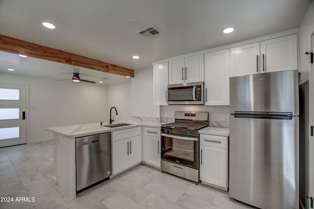 kitchen with white cabinetry, kitchen peninsula, appliances with stainless steel finishes, sink, and ceiling fan