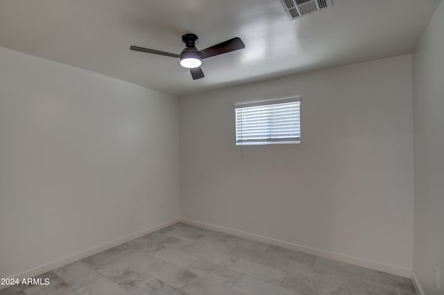 empty room with ceiling fan and light tile flooring