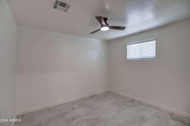 tiled empty room featuring ceiling fan