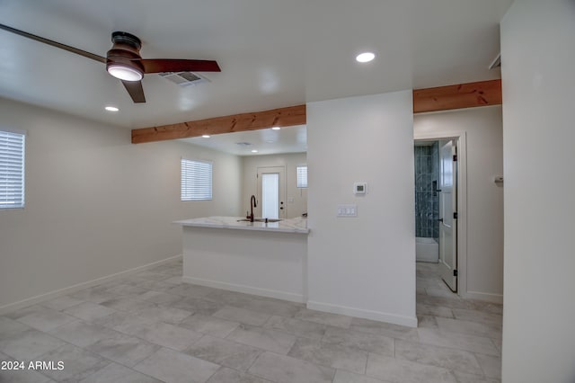 kitchen with sink, kitchen peninsula, ceiling fan, and light tile floors