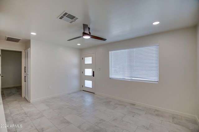 tiled empty room featuring ceiling fan