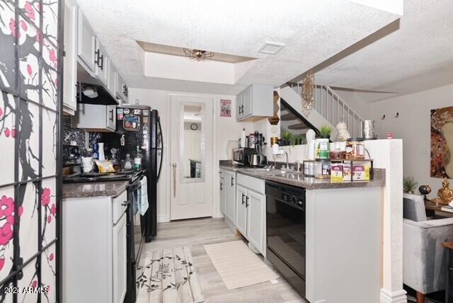 kitchen with sink, dishwasher, electric range oven, a textured ceiling, and white cabinets