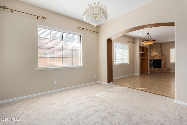 unfurnished living room with a fireplace, carpet flooring, and a wealth of natural light