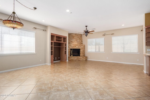 unfurnished living room featuring a fireplace, light tile patterned floors, ceiling fan, and built in shelves