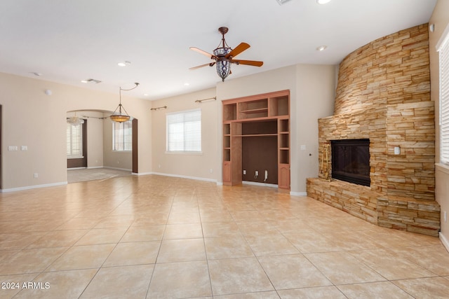 unfurnished living room with a fireplace, ceiling fan, and light tile patterned flooring