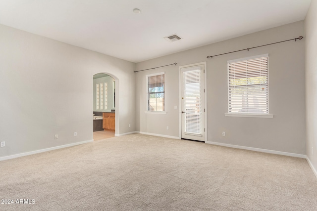 unfurnished room featuring light carpet