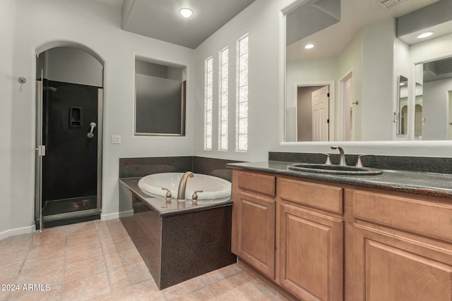 bathroom featuring tile patterned floors, plus walk in shower, and vanity