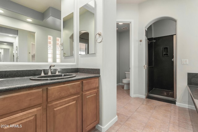 bathroom with tile patterned floors, vanity, toilet, and an enclosed shower