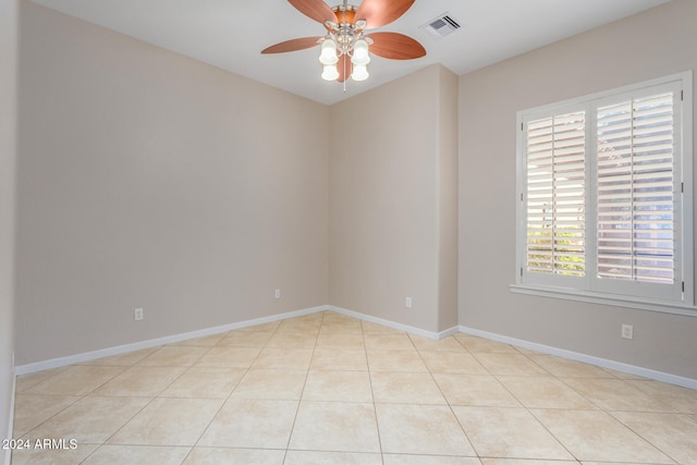 spare room with ceiling fan and light tile patterned flooring