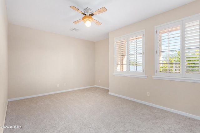 carpeted spare room with ceiling fan