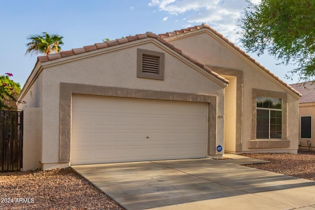 10735 W Bermuda Dr, Avondale, AZ 85392 - view of front of home featuring concrete driveway, stucco siding, an attached garage, a tiled roof, and fence