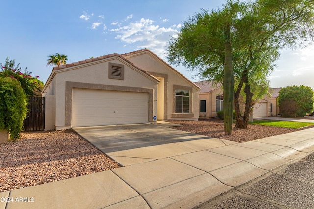 10735 W Bermuda Dr, Avondale, AZ 85392 - mediterranean / spanish house featuring stucco siding, a garage, driveway, and fence