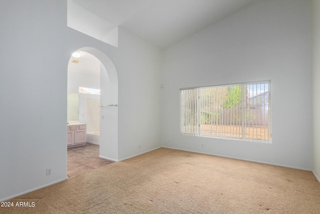 10735 W Bermuda Dr, Avondale, AZ 85392 - unfurnished room featuring light carpet, high vaulted ceiling, baseboards, and arched walkways