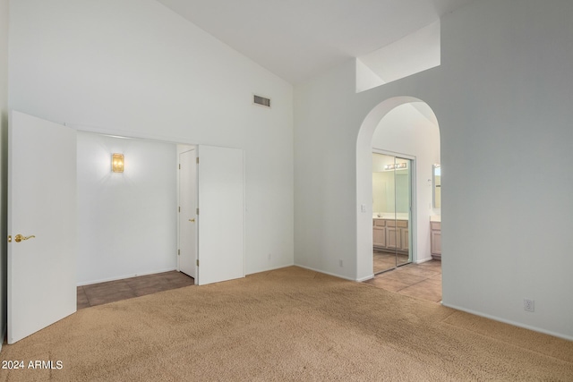 10735 W Bermuda Dr, Avondale, AZ 85392 - unfurnished room featuring high vaulted ceiling, light carpet, and arched walkways