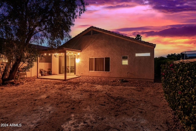 10735 W Bermuda Dr, Avondale, AZ 85392 - back of house at dusk with a patio and stucco siding