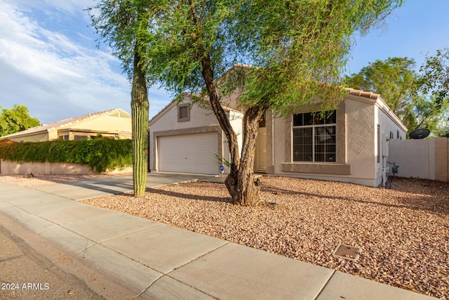 10735 W Bermuda Dr, Avondale, AZ 85392 - view of front of property with stucco siding, concrete driveway, a garage, a tiled roof, and fence
