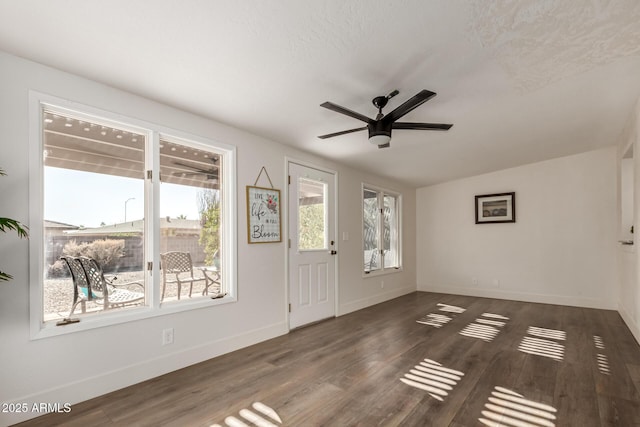 foyer entrance with ceiling fan, dark wood-style flooring, and baseboards