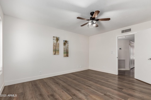 unfurnished room featuring baseboards, visible vents, and dark wood-style flooring