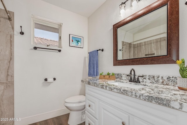 full bath with baseboards, a shower, toilet, wood finished floors, and vanity