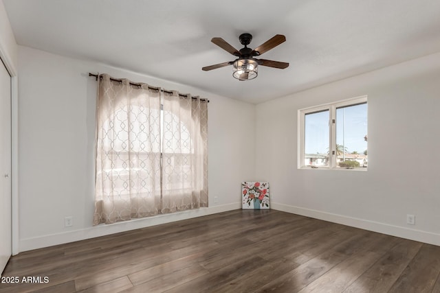 spare room featuring ceiling fan, baseboards, and dark wood-type flooring