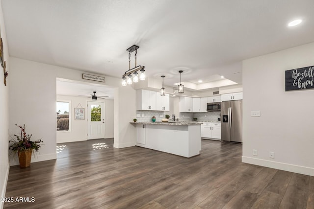 kitchen with kitchen peninsula, stainless steel appliances, ceiling fan, white cabinets, and hanging light fixtures