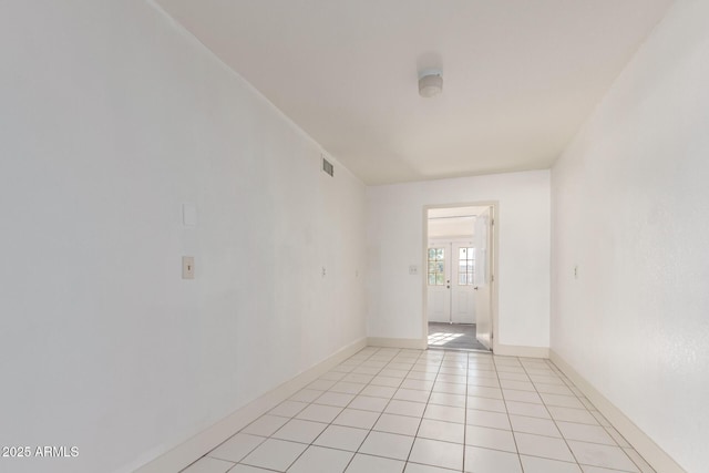 empty room with light tile patterned floors, baseboards, visible vents, and french doors