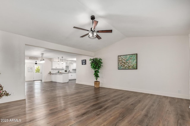 unfurnished living room featuring vaulted ceiling, dark wood-style flooring, ceiling fan, and baseboards