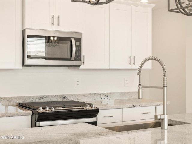 kitchen with light stone counters and appliances with stainless steel finishes