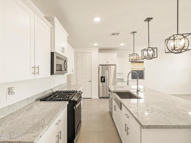 kitchen featuring sink, a center island with sink, appliances with stainless steel finishes, pendant lighting, and white cabinets