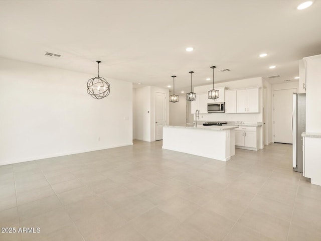 kitchen with sink, white cabinetry, decorative light fixtures, an island with sink, and stainless steel appliances