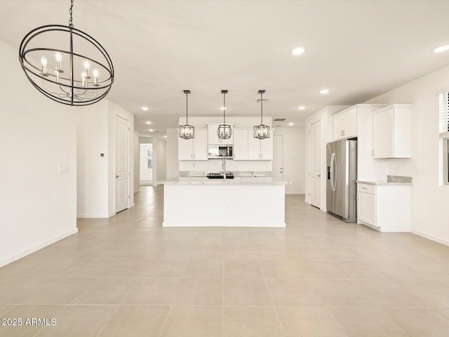 kitchen with white cabinetry, hanging light fixtures, stainless steel appliances, a notable chandelier, and an island with sink