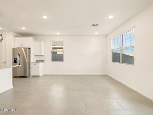 kitchen with white cabinetry and stainless steel fridge with ice dispenser