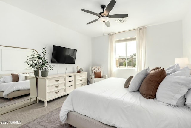 bedroom featuring visible vents, a ceiling fan, and light colored carpet