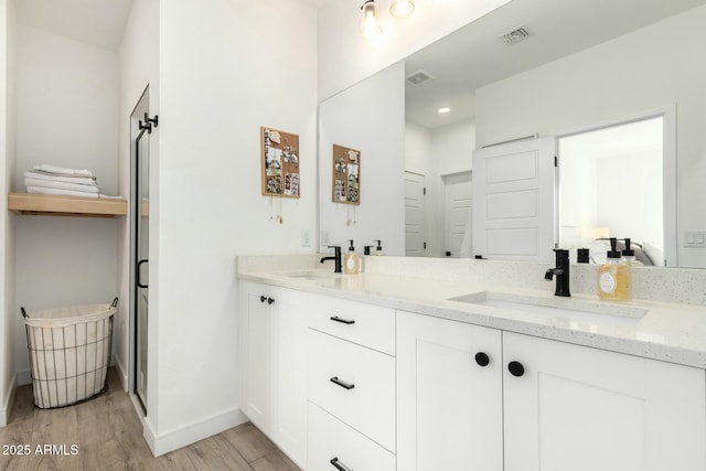 bathroom with visible vents, a sink, and wood finished floors