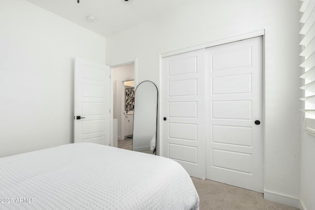 bedroom featuring light carpet and a closet