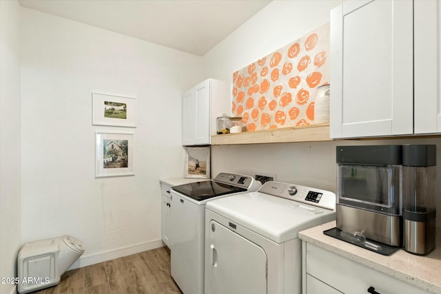 clothes washing area featuring light wood-type flooring, washing machine and dryer, cabinet space, and baseboards