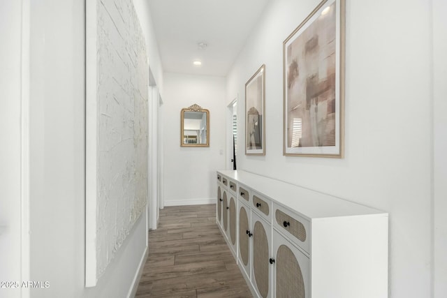 hallway featuring baseboards and wood finished floors