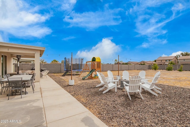 view of yard with a fenced backyard, a trampoline, a playground, and a patio