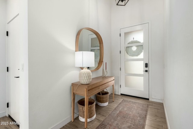 foyer entrance with baseboards and wood finished floors