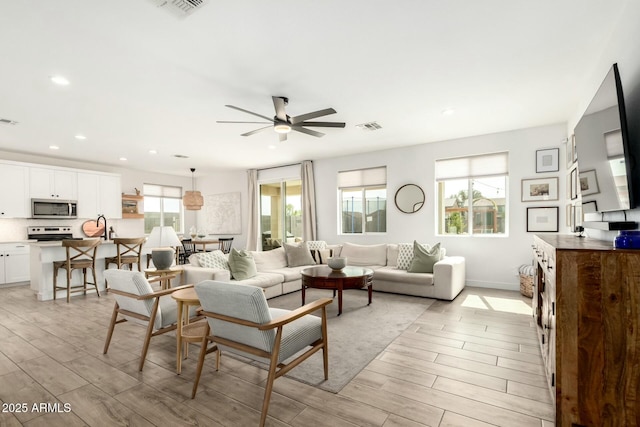 living area featuring light wood finished floors, visible vents, and recessed lighting