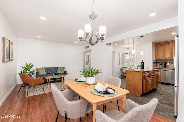 dining area with dark hardwood / wood-style floors and an inviting chandelier