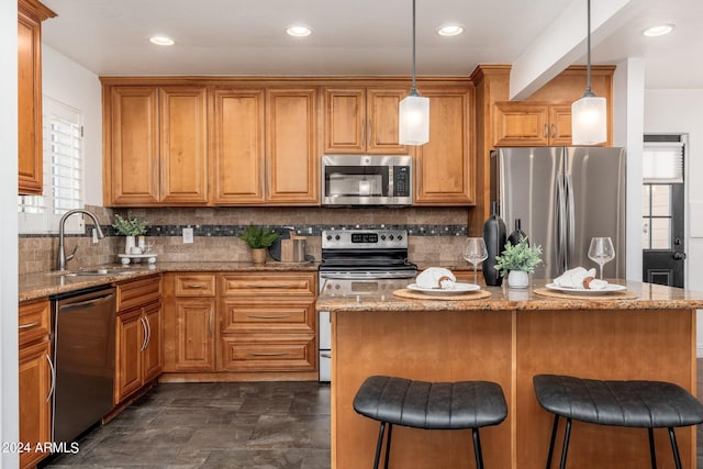 kitchen featuring stainless steel appliances, sink, a center island, decorative light fixtures, and light stone counters