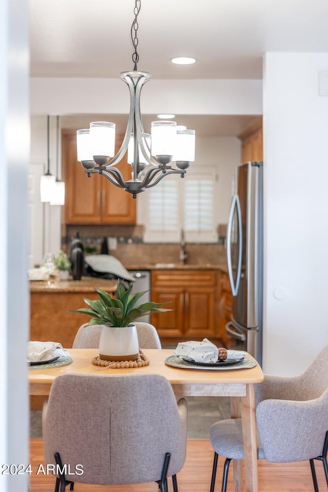 kitchen with an inviting chandelier, stainless steel fridge, and wood-type flooring