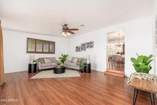 living room with wood-type flooring and ceiling fan with notable chandelier