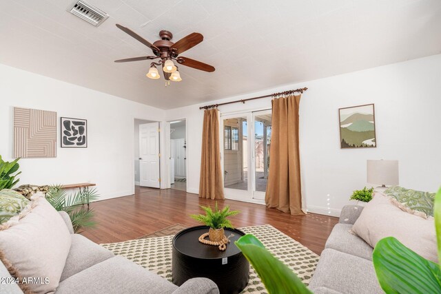 living room with ceiling fan and dark hardwood / wood-style flooring