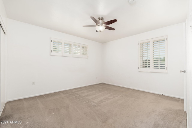 spare room featuring ceiling fan and light colored carpet