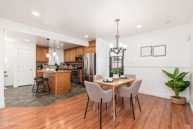 dining area with dark wood-type flooring and a chandelier