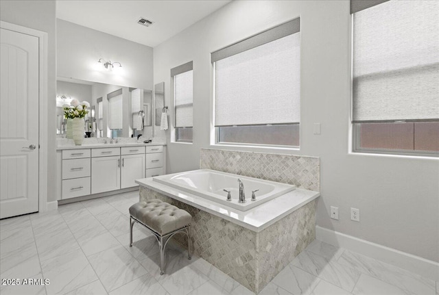 full bath with visible vents, baseboards, marble finish floor, vanity, and a garden tub