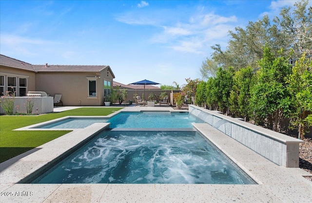 view of pool with a patio, fence, a pool with connected hot tub, and a yard