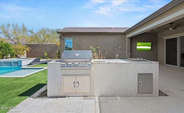 view of patio featuring fence, a fenced in pool, an outdoor kitchen, and area for grilling